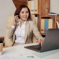 confident-ethnic-businesswoman-speaking-phone-office